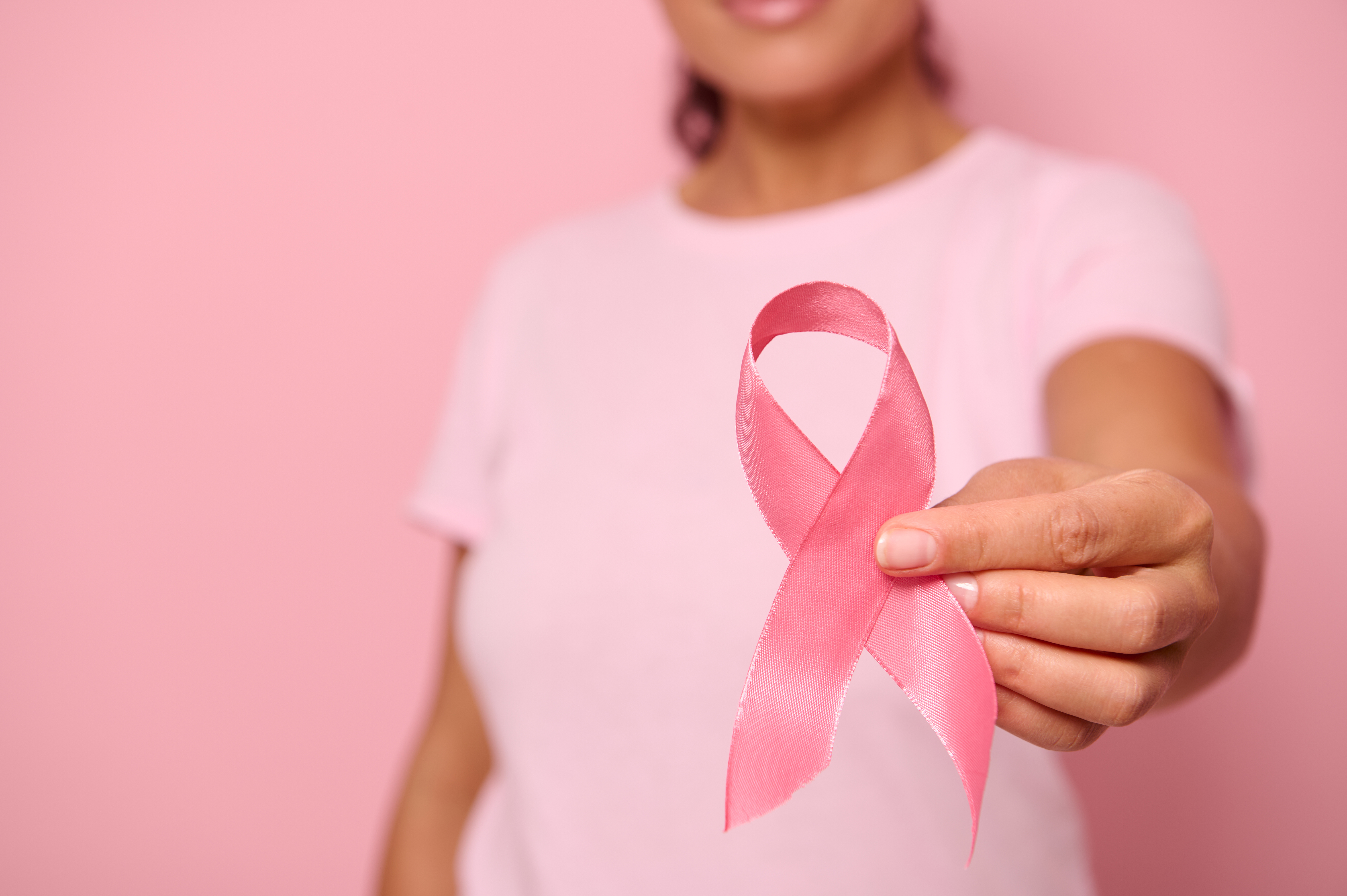 fermer-main-de-femme-en-t-shirt-rose-tenant-un-ruban-rose-journee-mondiale-contre-le-cancer-sensibilisation-au-cancer-du-sein-et-de-l-abdomen-journee-rose-d-octobre-sur-fond-colore-espace-de-copie-concept-de-soutien-au-cancer-du-sein